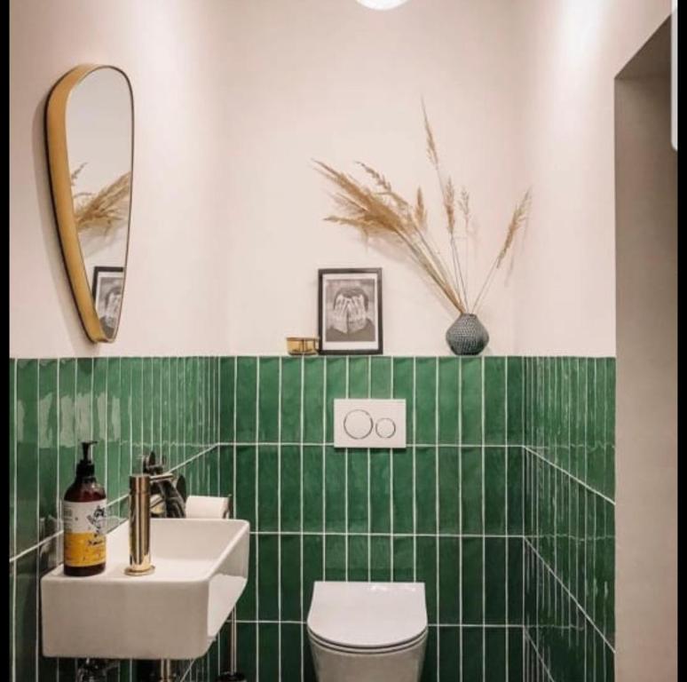 MUSITA GUEST WING MOTEL的一间带水槽和绿色瓷砖墙的浴室