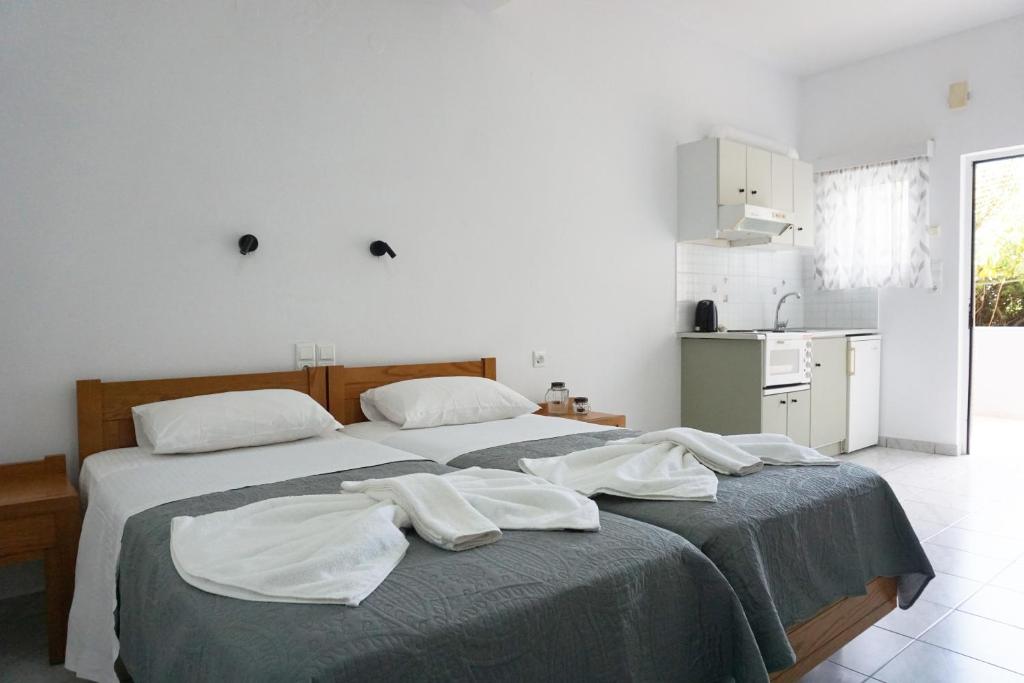 巴利恩Aphrodite Studios & Apartment的一间卧室配有两张床和白色毛巾。