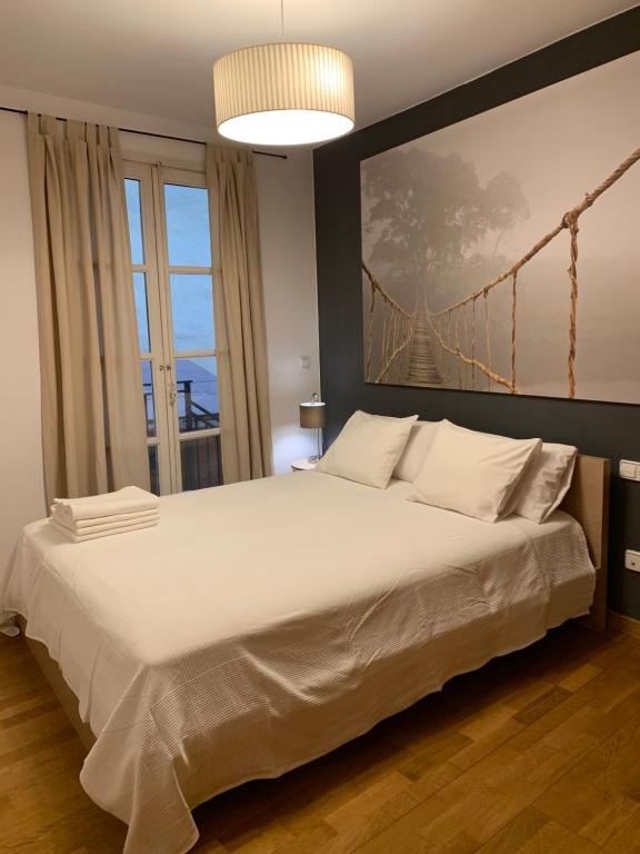 巴塞罗那Hermoso piso en el centro de Barcelona的卧室配有一张白色大床,墙上挂有桥画