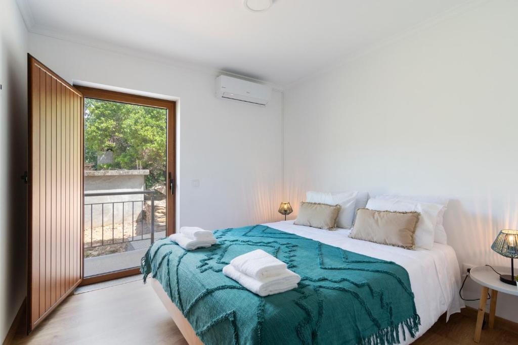 VideNEW - Casa das Domingas的白色的卧室设有一张大床和一个窗户
