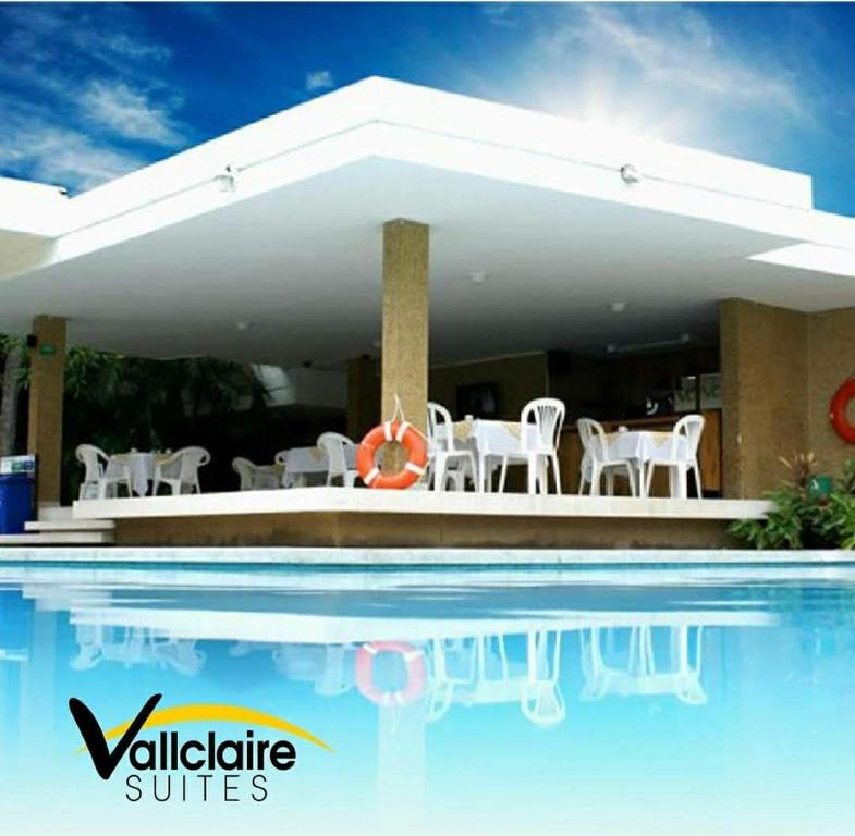 巴兰基亚巴比克莱尔套房公寓式酒店的一个带白色椅子的游泳池和一个游泳池