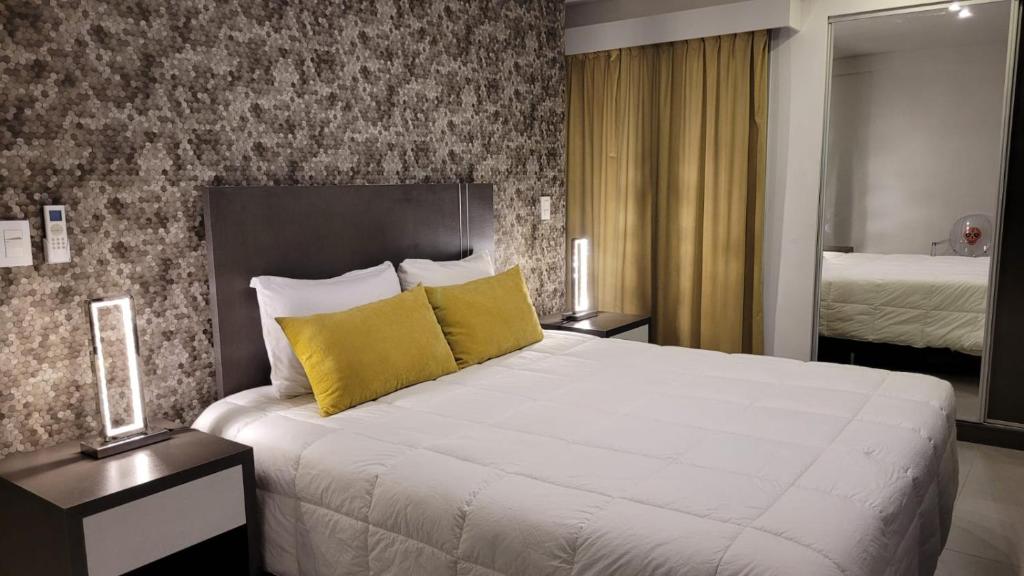 圣路易斯Be Haus Temporary Apartments的卧室配有一张带黄色枕头的大型白色床。