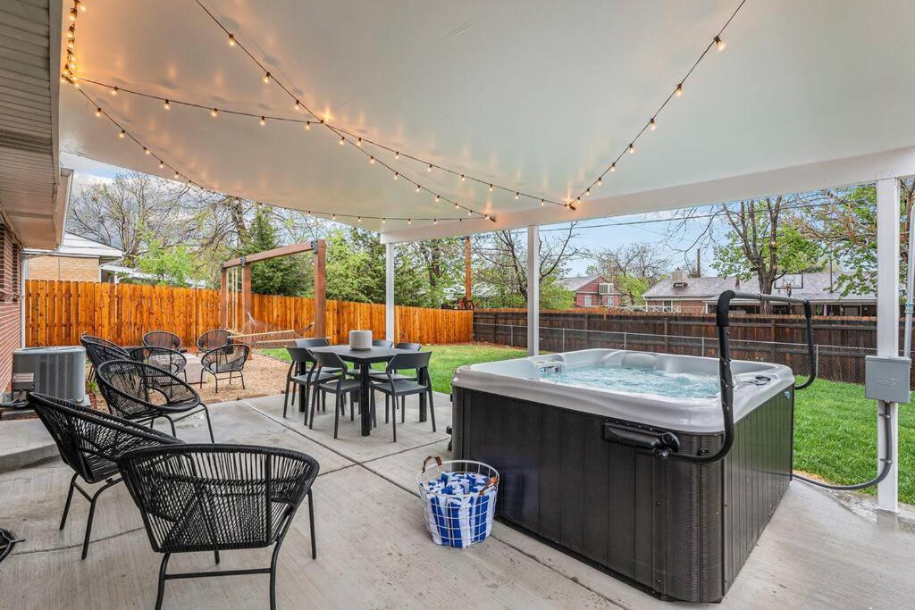 丹佛Mile Hi: Amenities Galore的庭院设有热水浴池、桌子和椅子。