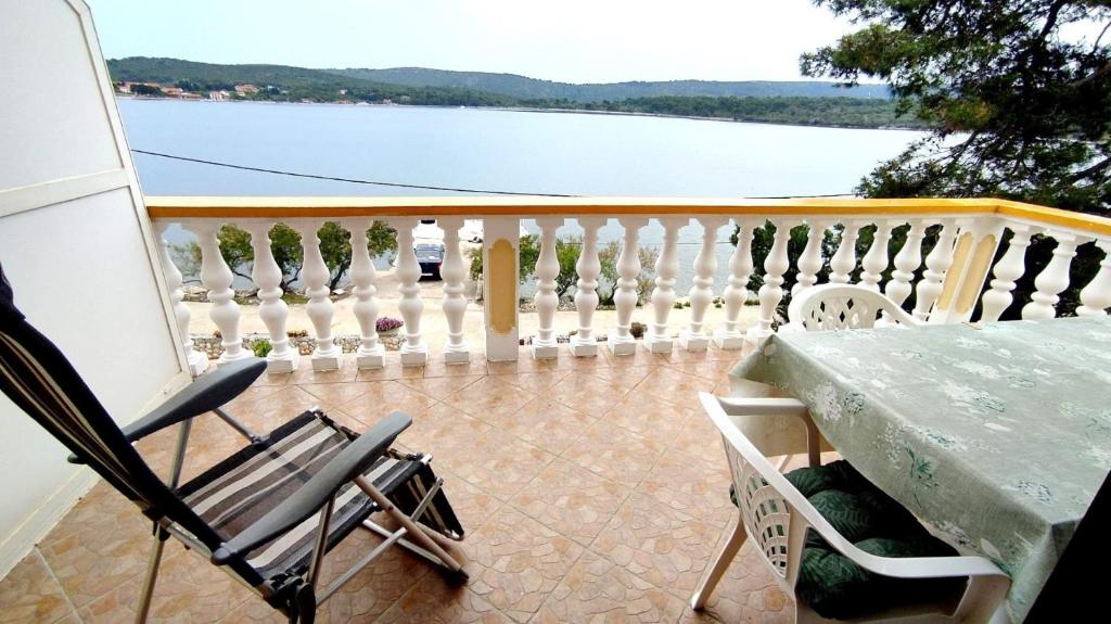韦利拉特Apartments Josef - sea view的阳台配有桌椅,享有水景。