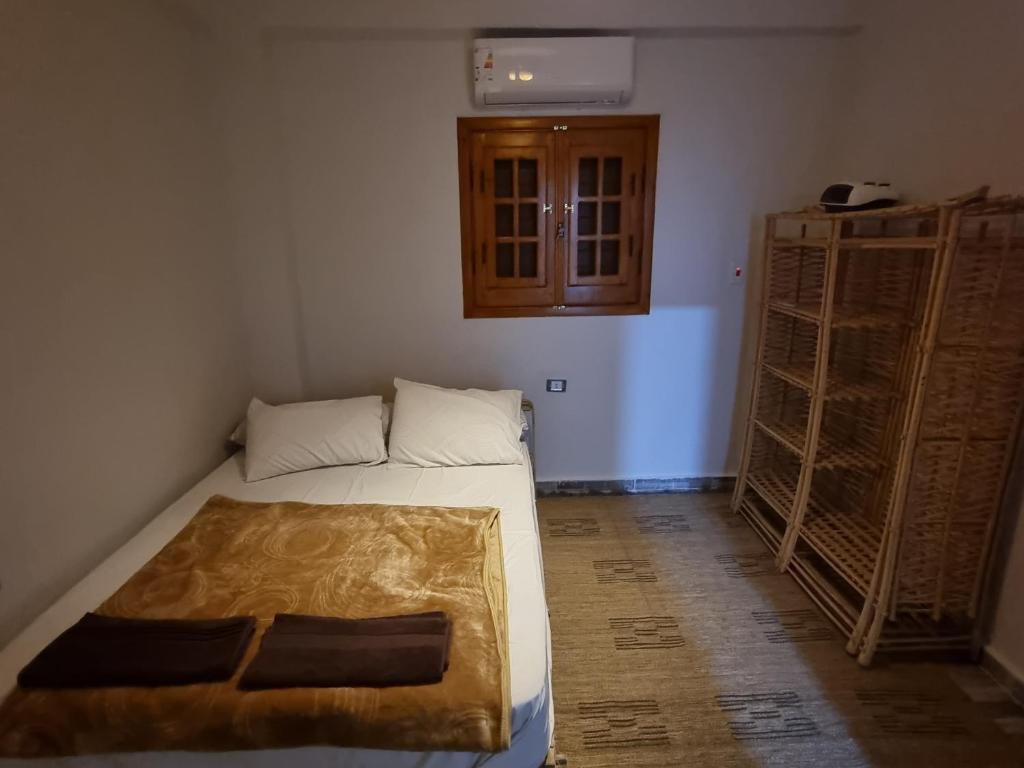 锡瓦SEMIRAmis Siwa的小房间设有床和一些架子