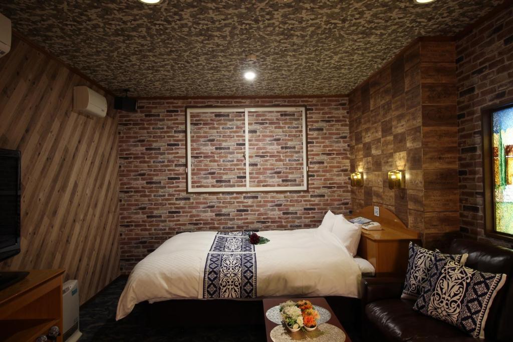 大仙市大人のホテルドルフィア的一间卧室设有一张床和砖墙