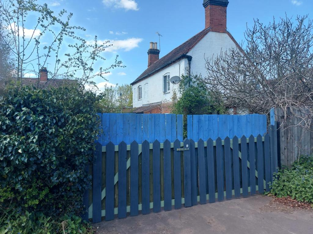 Walsgrave on Sowerosedale cottage的房屋前的蓝色围栏