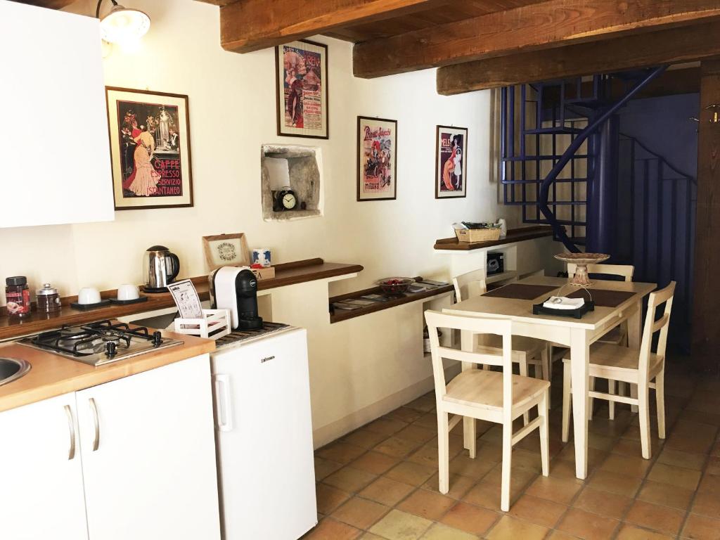 皮耶特拉佩尔托萨B&B Dimora Cigno的厨房配有白色橱柜和桌椅