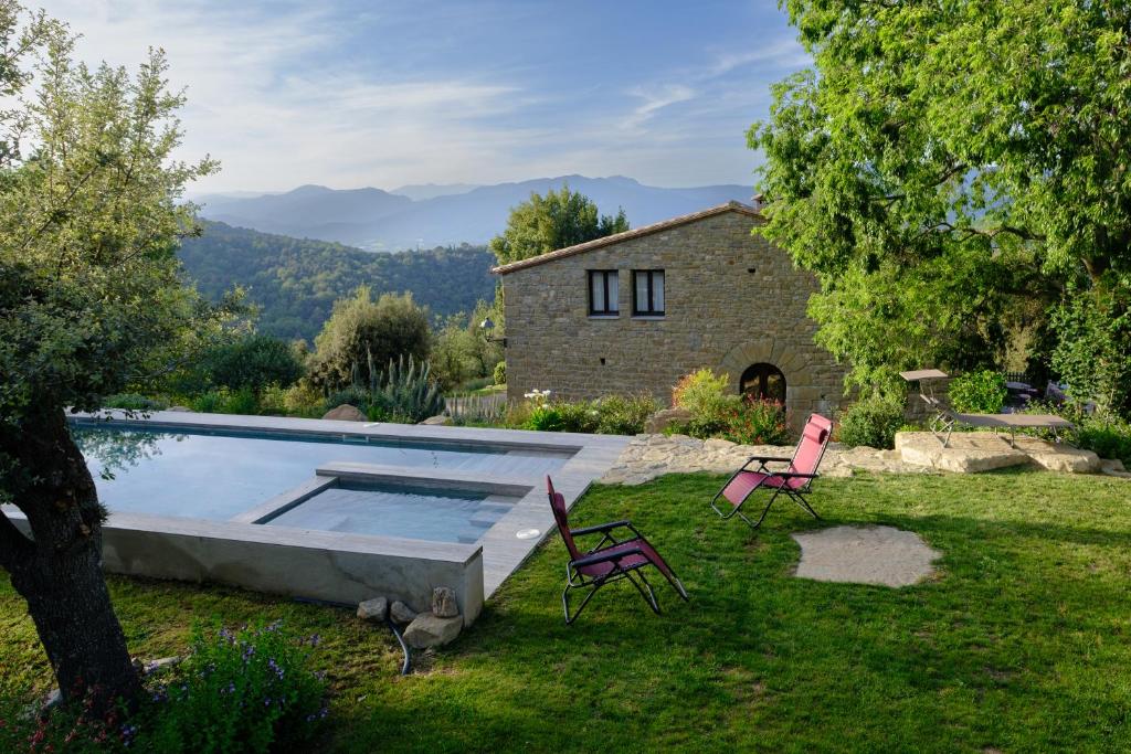 桑特费里奥尔Arc de can Puig Luxury Holiday Home in catalonia的一个带游泳池、两把椅子和房子的庭院