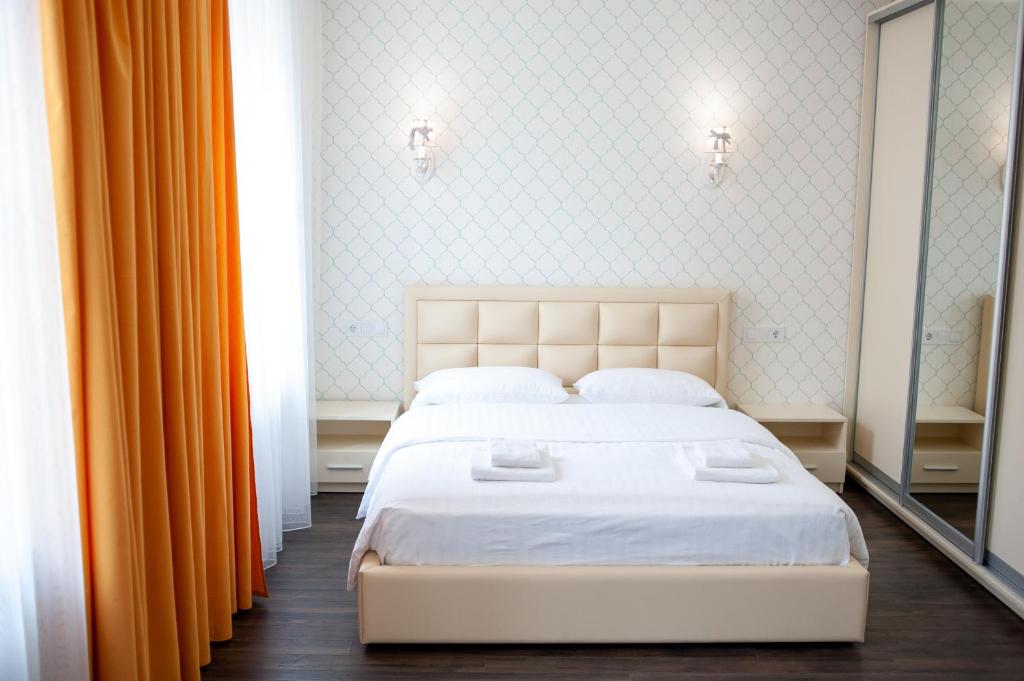利沃夫步行中心区ASAO公寓的卧室配有白色的床和橙色窗帘