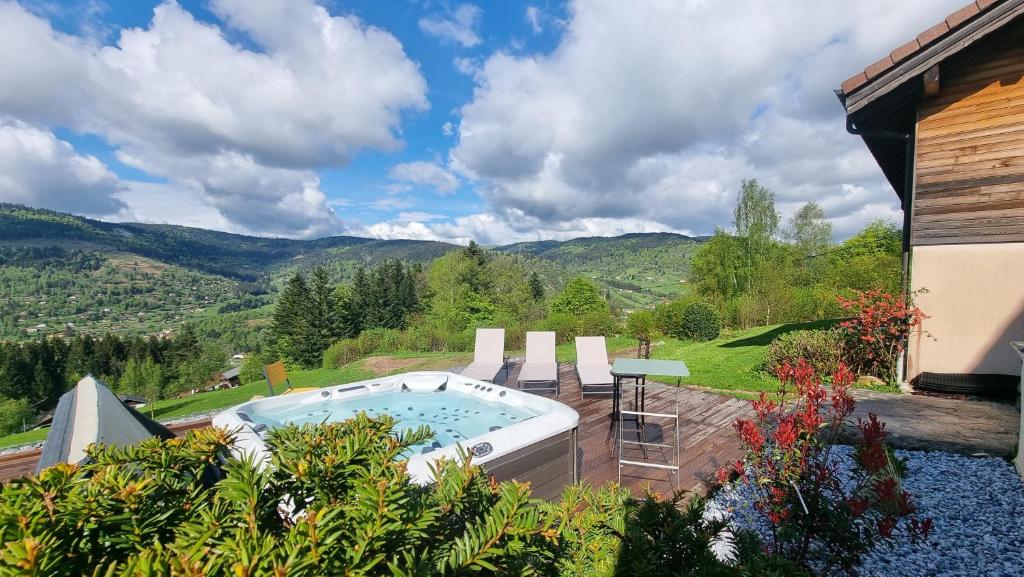旺特龙Chalet Terejo & spa的庭院内的一个热水浴池,享有山脉背景