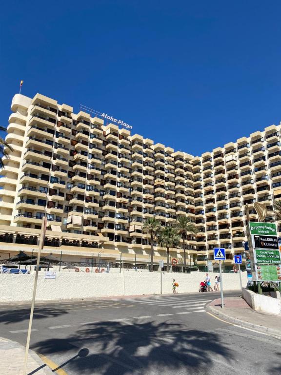 贝纳尔马德纳BENALMADENA ALOHA PLAYA BEACH LOFT的海滩上一座大型公寓楼,有一条街道