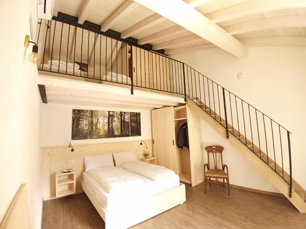 特雷莫西内appartamenti Residenza 1928的一间卧室设有一张床和一个楼梯
