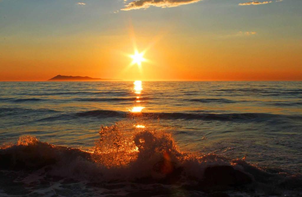 佩罗德斯Logas Beach Studios Peroulades Corfu的海浪,太阳在天空中