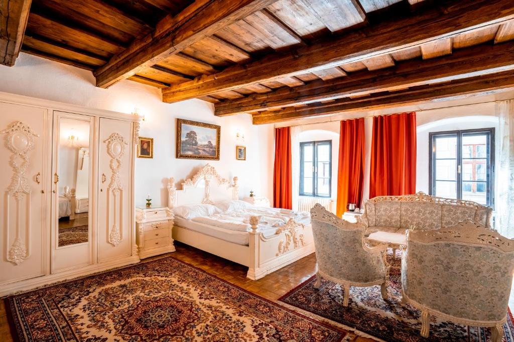 捷克克鲁姆洛夫莱拉里亚旅馆的卧室配有一张床和一张桌子及椅子