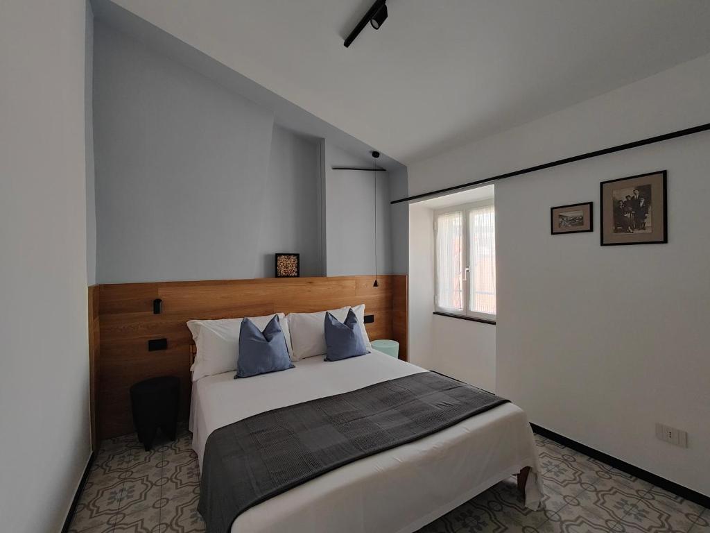 阿拉西奥Casa Aicardi的卧室配有带蓝色枕头的大型白色床