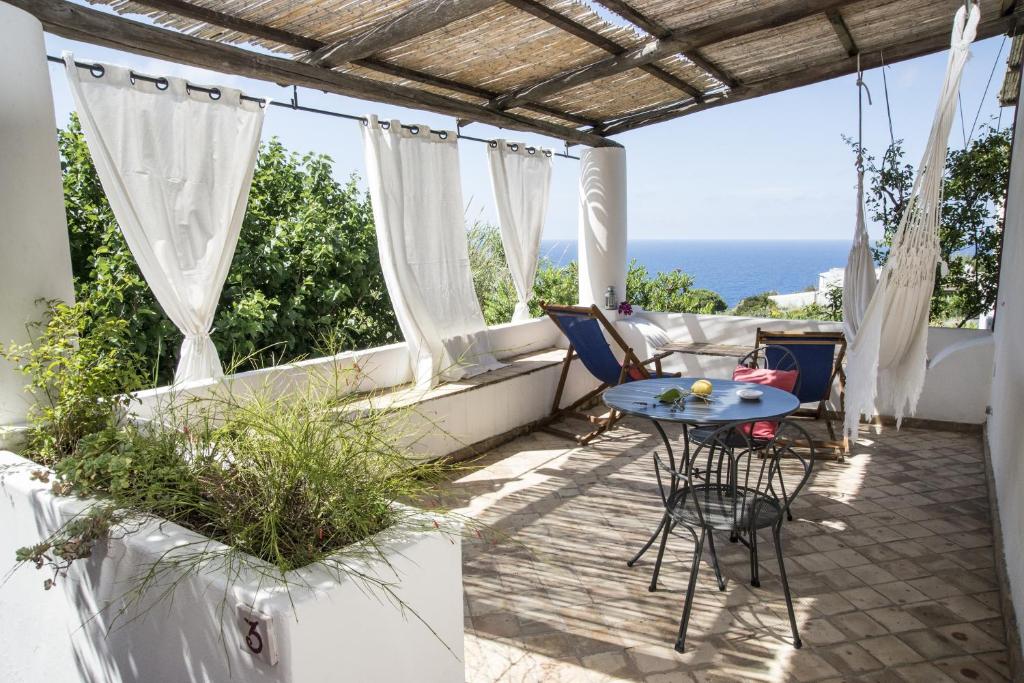 马尔法Il格尔索假期酒店的一个带桌椅的庭院和大海