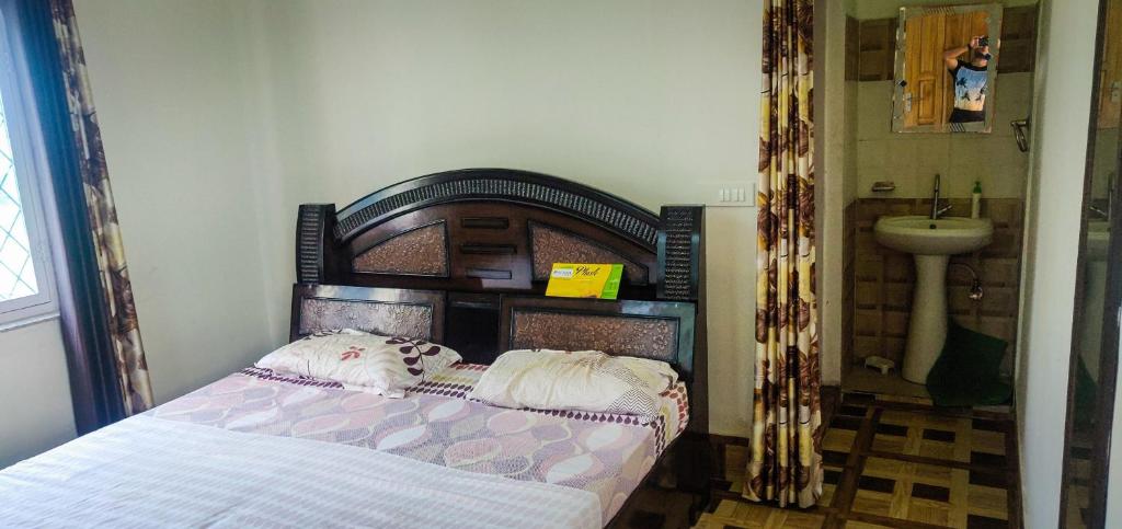 德拉敦Gaharwar Home Stay的一间卧室配有一张带木制床头板和水槽的床。