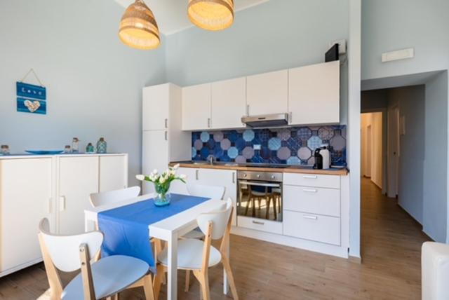 泰拉奇纳Mariviva Guest House的厨房配有蓝色桌子和白色橱柜