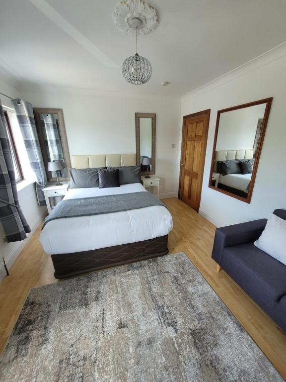 戈尔韦Grange House B&B的一间卧室配有一张大床和一张蓝色的沙发