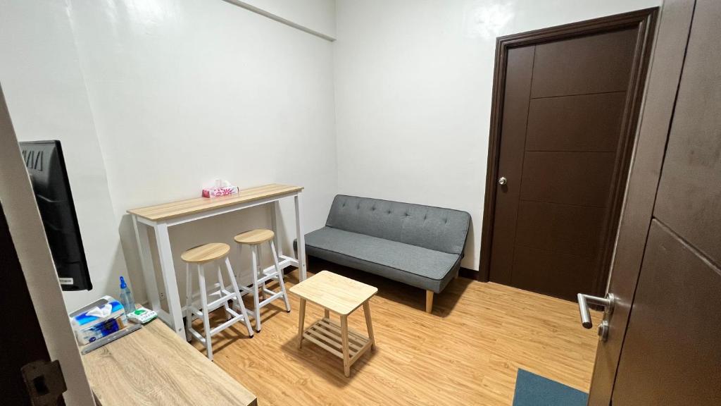 马尼拉Jannah’pad的小房间设有蓝色椅子和桌子