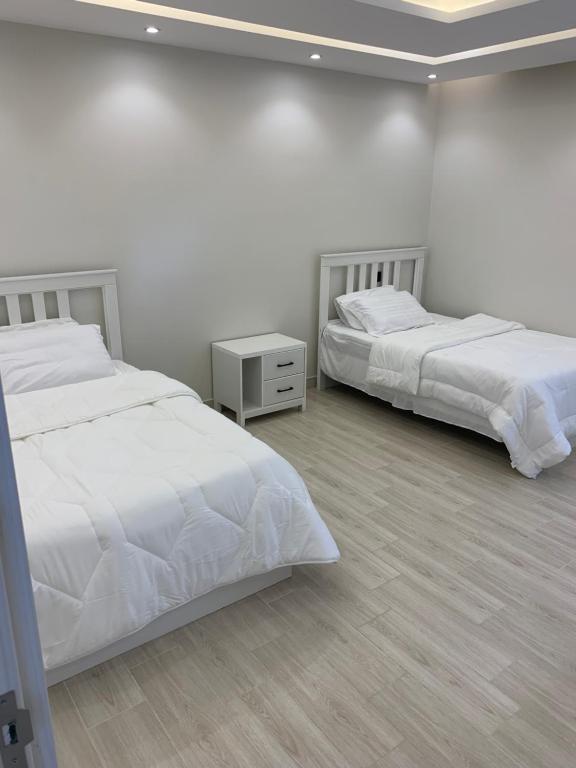 巴哈شاليه اوبل قاردن - OPAL GARDENS的卧室设有2张床和白色的墙壁。