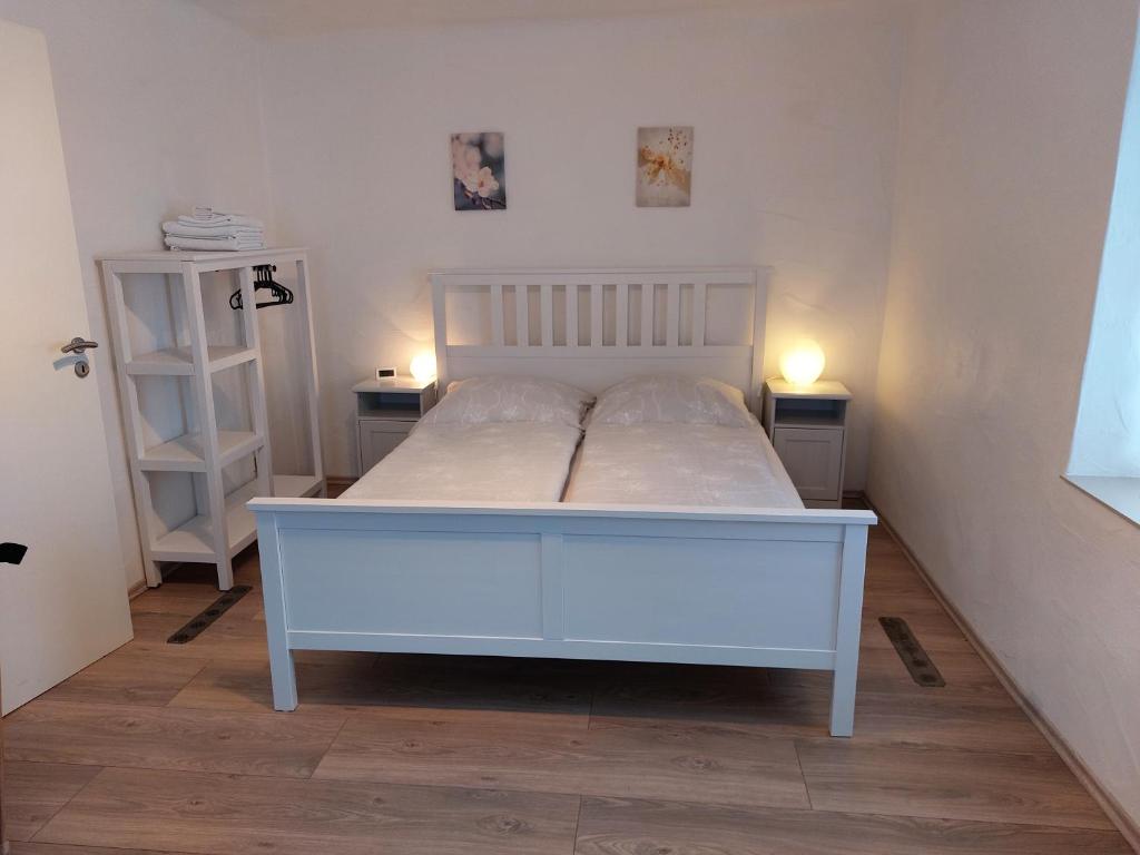 梅特拉赫Ferienhaus Schwalbennest的一张白色的床,房间有两个床头柜