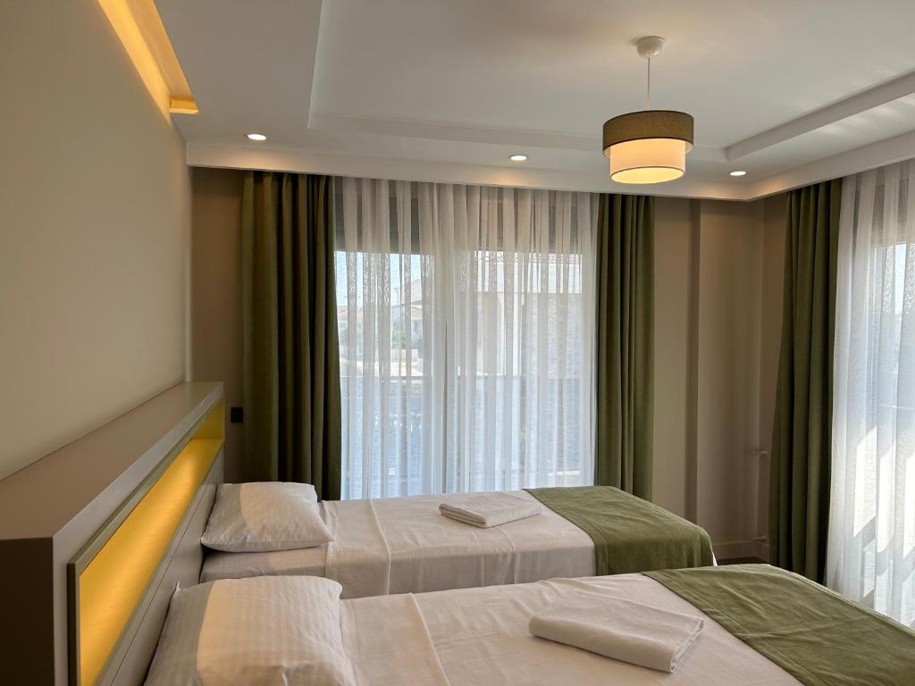 贝莱克Nirvana Belek Villas的酒店客房设有两张床和窗户。