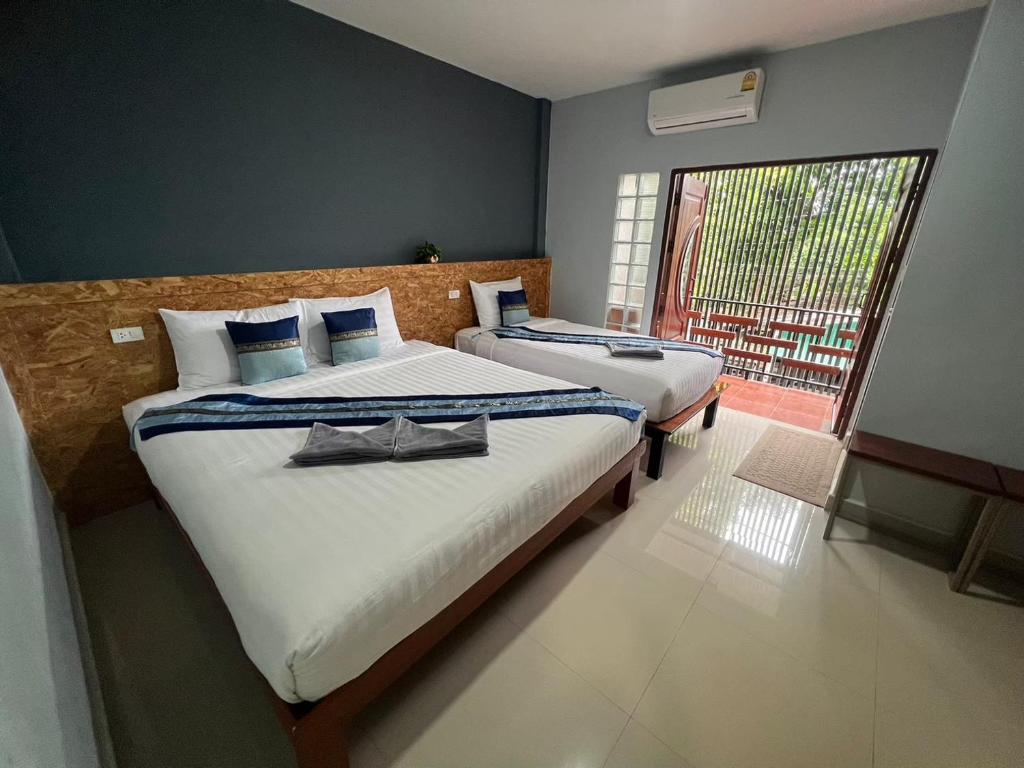 Sungai KolokThe Sekret Hotel的一间卧室设有两张床和一个美景窗户。