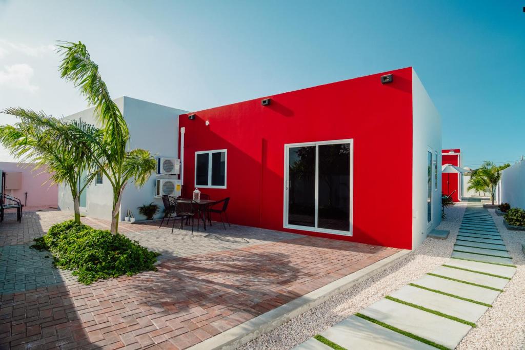 Santa CruzTrankilidad Apartments的前面有棕榈树的红色房子