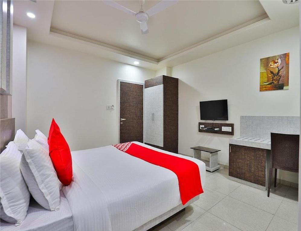 德瓦尔卡The Sky Comfort Hotel Parth Inn的卧室配有带红色枕头的白色床