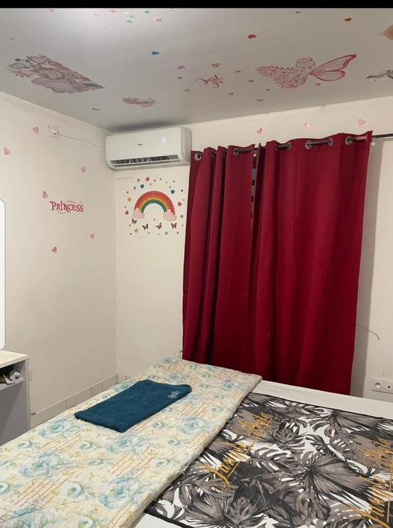 卡宴La sagesse的一间设有红色窗帘和床的房间