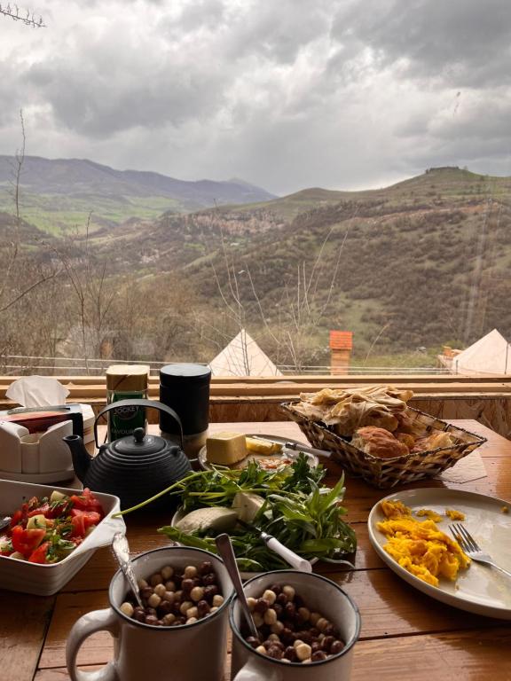 DseghAlereks Mountain Camping的餐桌上放有盘子的餐桌,享有美景