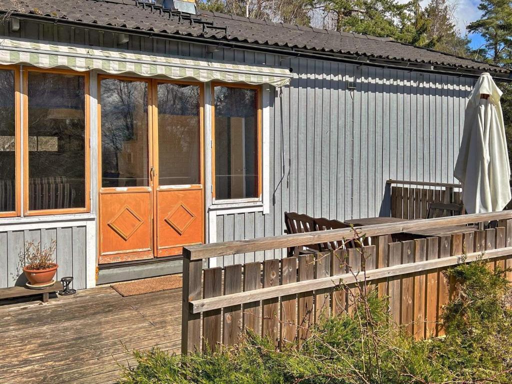 EkebyHoliday home MUNSö的一座带木栅栏和门廊的房子