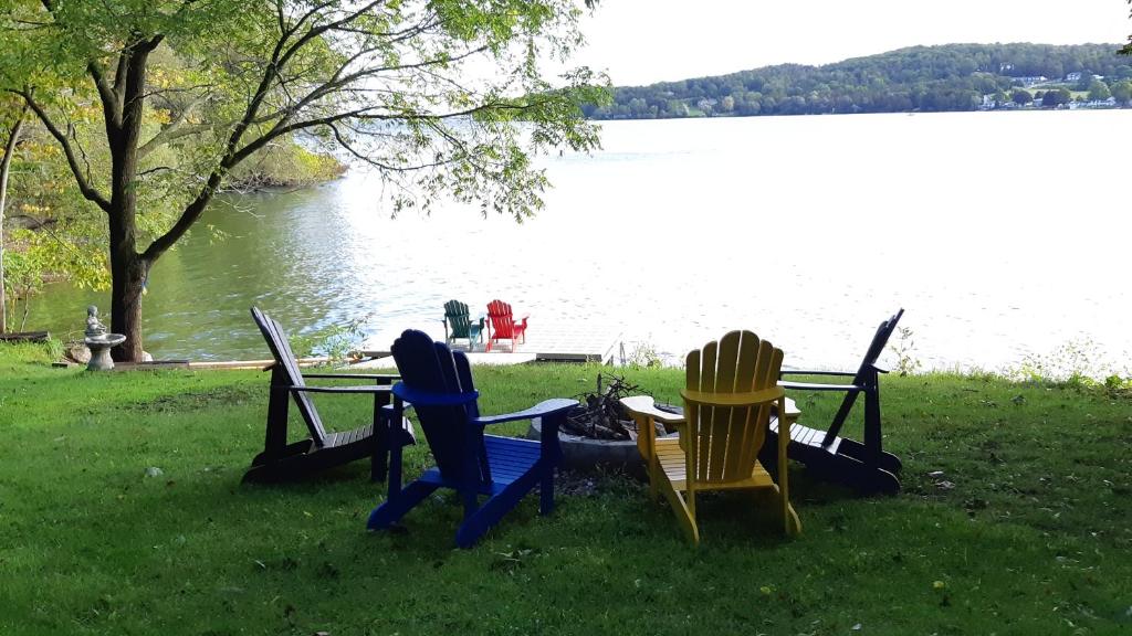 皮克顿Eliken House Suites的坐在湖边草地上的一组椅子