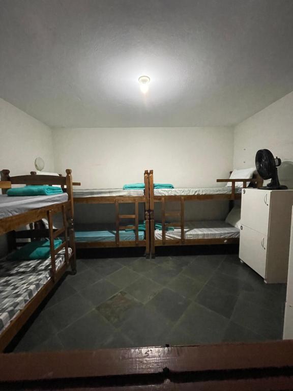 瓜拉派瑞Hope Hostel Guarapari的客房设有两张双层床和一台冰箱。