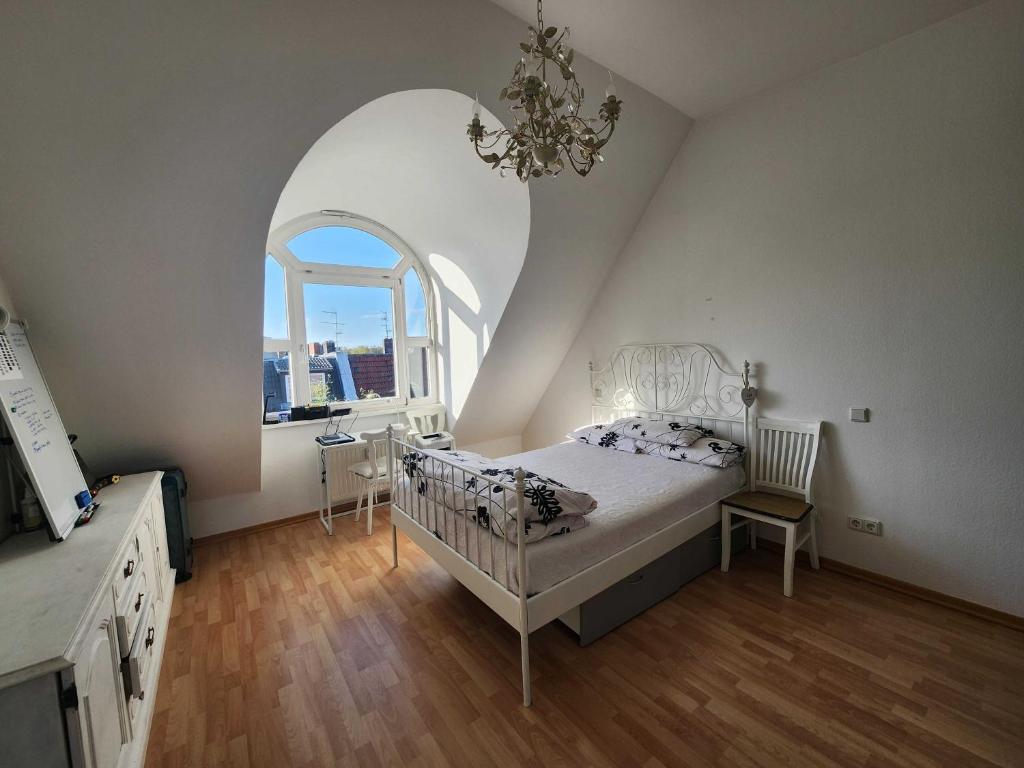 柏林One Private room available in a two room apartment in Tegel, Berlin的卧室配有白色的床和拱形窗户