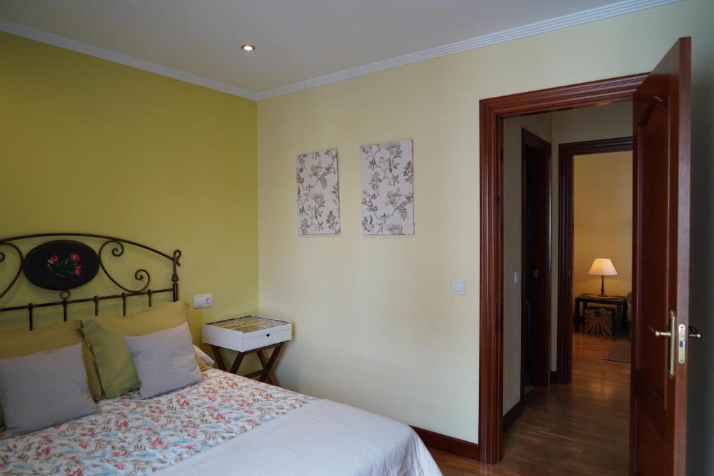 卢安科ALMAR, Apartamento en Luanco.的一间卧室设有一张床,门通往走廊