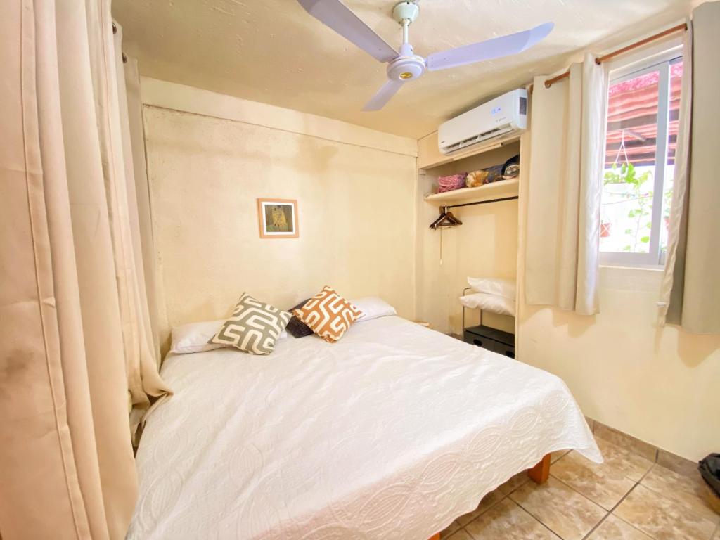 伊斯塔帕Casa ALOA Ixtapa的一间卧室配有一张带吊扇的床