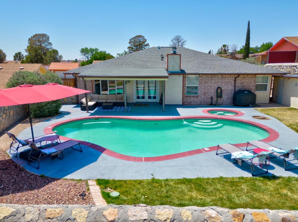 埃尔帕索Home with Mountain View/Pool/Tub的一个带椅子的游泳池以及一座房子