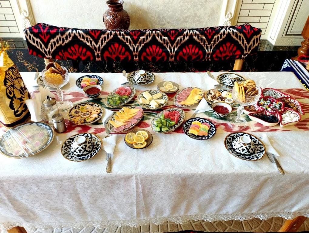 撒马尔罕ASR GUEST HOUSE的一张桌子上放着许多盘子的食物