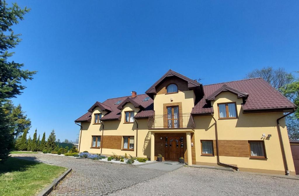 PołchowoNa Wzgórzu的棕色屋顶的大型黄色房屋