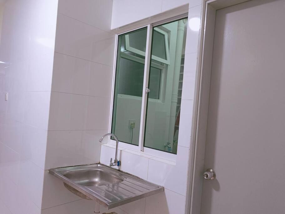 山打根IJM Homestay Condominium的浴室水槽、镜子和窗户