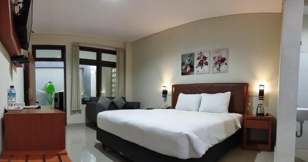 TjakranegaraLombok Mayura Hotel的卧室配有一张白色大床和一把椅子