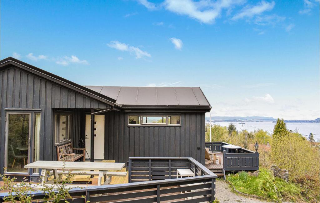 KopervikAwesome Home In Kopervik With Wifi的前面有一张野餐桌的黑色房子