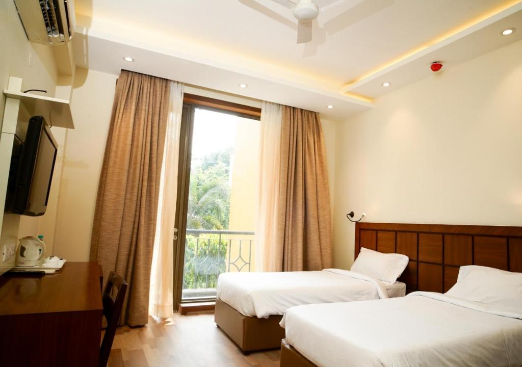 新德里UDS Villa Scandinavian B&B - Next to VFS的酒店客房设有两张床和窗户。