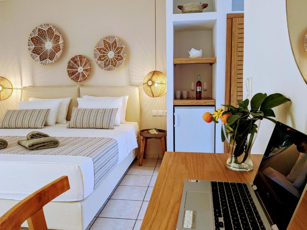 克里奥斯Villa Karina的一间卧室配有一张床和一张桌子上的笔记本电脑
