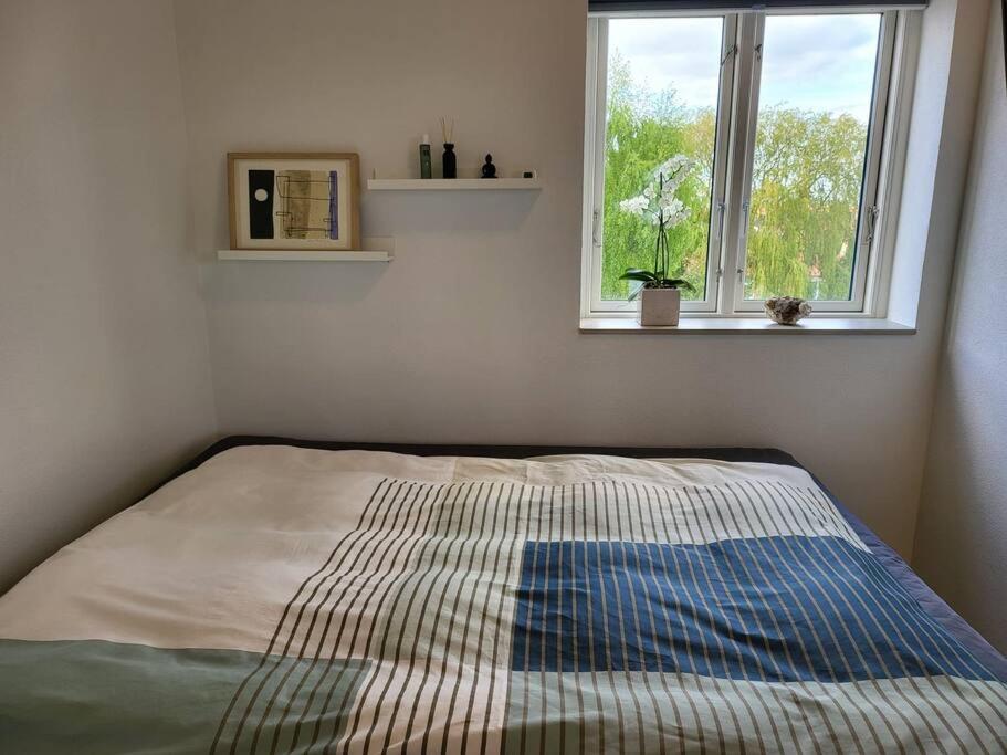 Solrig og moderne villalejlighed tæt på midtbyen的窗户客房内的一张床位