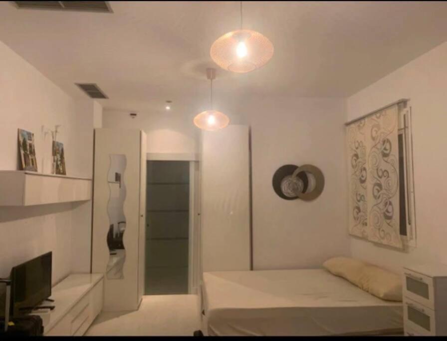 塞维利亚Relator的白色的客房配有床和电视