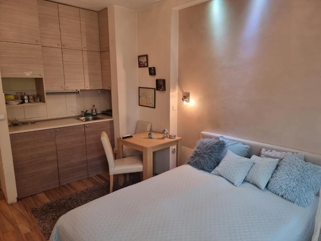 乌日策波姆蚌耶拉公寓的一间卧室配有一张床铺和一张桌子,还设有一间厨房
